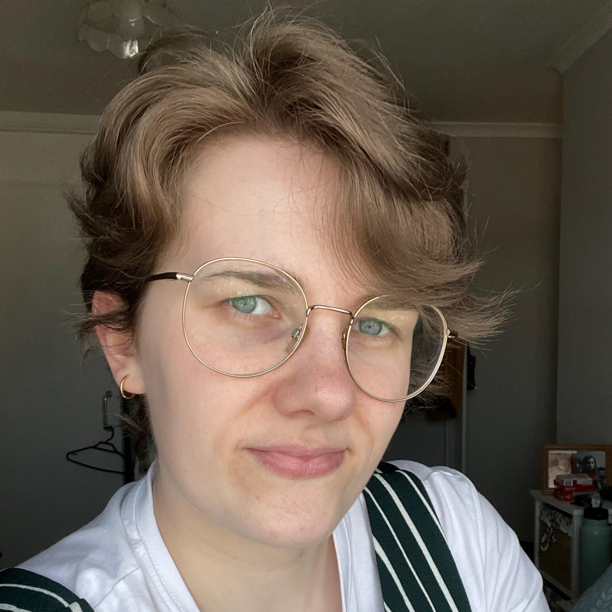 A photograph of me: short brunette hair, wearing glasses, and smiling at the camera.